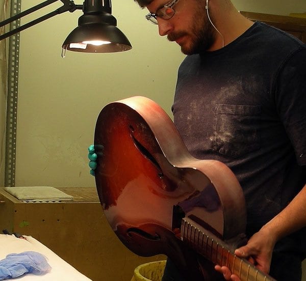 Luthier Kaleb Fitting sands a custom BRAVO in between coats of lacquer Benedetto Guitars 9-9-2014